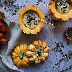 pumpkins, gourds and seeds are arranged on a table with spoons