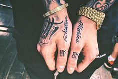 two people with tattoos on their hands are holding onto one another's fingers and the other