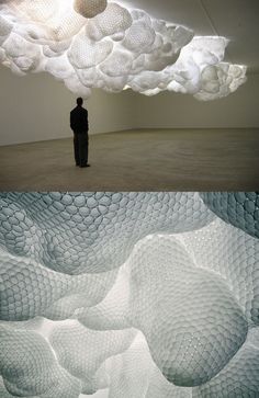 two pictures one with a man standing in front of an art piece and the other with clouds above it