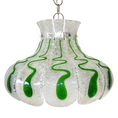 a green and white vase hanging from a chain