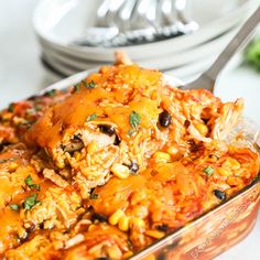 a casserole dish with chicken, rice and beans in it on a table