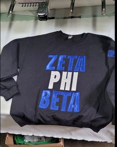 a black sweatshirt with the words zeta phi beta on it