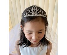 ❤ Please visit my shop for more flower girl accessories! https://www.etsy.com/shop/FromClareWithLove?ref=simple-shop-header-name&listing_id=792236877§ion_id=32556451 Veil Length 22-23 Inches (Approx.) ❤ During shipping, the veil will develop wrinkles. Hang the veil from a high rod or door and let any small wrinkles release naturally. If it doesn't work, you can put it in the shower to absorb steam during your shower. (Do Not put it inside the actual shower or let water touch it)  Using steamer - Hold the wand of the steamer. From the top of the veil - about 6 to 8 inches away from the material. Communion Cross Tiara with Veil | Communion Tiara and Veil | Rhinestone Cross Tiara Tiara With Veil, Tiara And Veil, Communion Tiara, Kids Tiara, Mini Bride, Wrinkle Release, Flower Girl Accessories, Veil Length, Wedding Veil Accessories