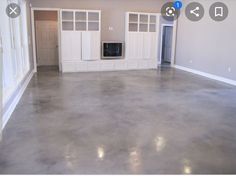 an empty living room with white cabinets and gray flooring is pictured in this image