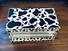 an animal print box sitting on top of a wooden floor