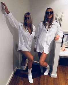 two women dressed in white posing for the camera