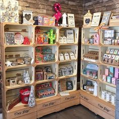 two wooden shelves filled with lots of different types of cards and gifts on display in a store