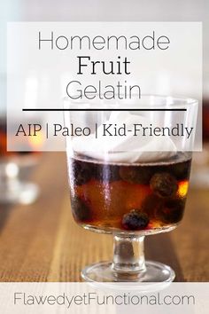 homemade fruit gelatin in a glass on top of a wooden table with text overlay that reads homemade fruit gelatin aip pale kid - friendly