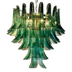 a green glass chandelier hanging from a ceiling fixture with multiple lights on it