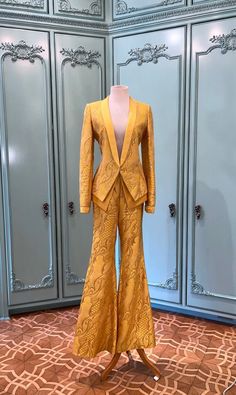 This silk blazer pantsuit is from Wes Gordon's Fall 2003 Runway. The color is a stunning canary yellow with a silver lurex brocade design all through out. The blazer includes a double layer made of yellow silk satin and a high waist flared pant leg. Truly Magnificent. Wes Gordon interned with Oscar De La Renta and Tom Ford after graduating from Central St. Martins in 2009, the same year he launched his own self named line of women's wear. In 2018, he took over at Carolina Herrera as creative director. Blazer and Pant size: 6 Brocade Blazer Women, Elegant Formal Pantsuit For Festive Occasions, Elegant Festive Pantsuit For Formal Occasions, Elegant Festive Formal Pantsuit, Yellow Long Sleeve Party Set, Yellow Long Sleeve Blazer For Party, Long Sleeve Yellow Blazer For Party, Elegant Yellow Pantsuit For Spring, Yellow Long Sleeve Suit For Formal Occasions