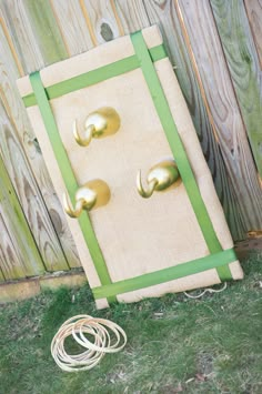 the door is made out of burlock and green ribbon with brass hardware on it