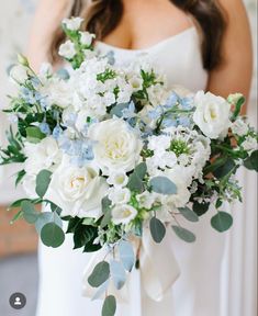 a bridal holding a bouquet of white and blue flowers