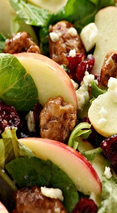 a salad with apples, cranberries and walnuts in it is ready to be eaten