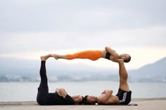 two people are doing yoga on the beach