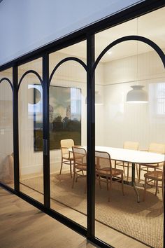 an office with glass walls and tables in it