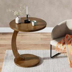 a chair and table on a rug in a room with hardwood floors, white walls and wooden flooring