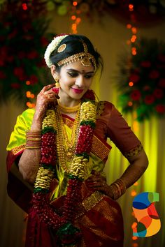 a woman in a red and yellow sari is holding her hands on her hips