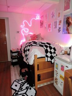 a bed room with a neatly made bed and a neon sign on the wall above it