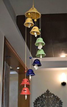 several different colored bells hanging from a ceiling