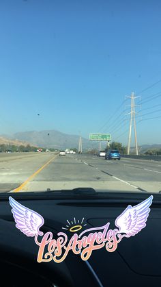 the windshield of a car with an angel sticker on it that says los angeles