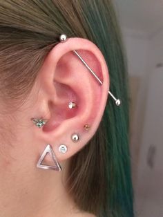 a woman with green hair wearing ear piercings