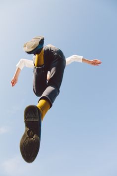 a man flying through the air while riding a skateboard in front of a blue sky