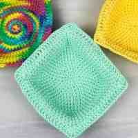 three crocheted dishcloths sitting next to each other