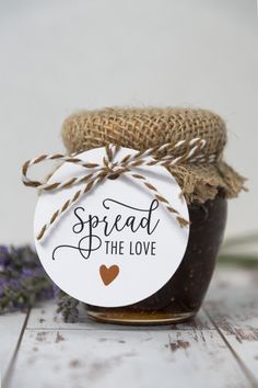 a jar filled with jam sitting on top of a wooden table next to lavender flowers