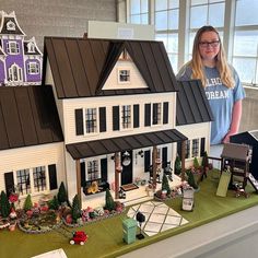 a woman standing in front of a model house