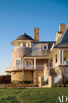 a large stone house with two story windows on the second floor and an upper level balcony