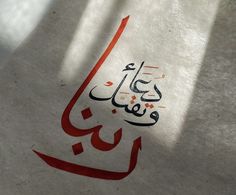 an arabic calligraphy is shown on a piece of paper with red writing in it