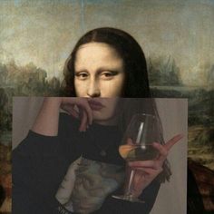 a woman holding a wine glass in front of her face with the painting behind her