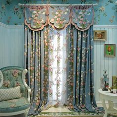 a living room with blue walls and floral curtains