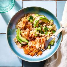 a blue bowl filled with rice, meat and avocado