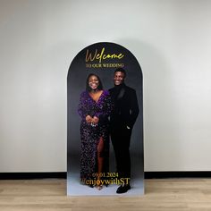 a couple posing for a photo in front of a welcome sign that says welcome to our wedding