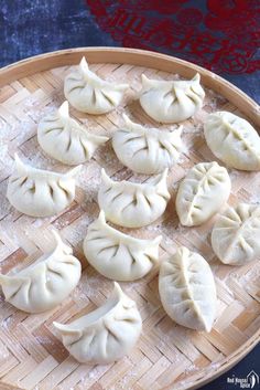 some dumplings are sitting on a bamboo tray