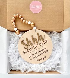 a wooden sign in a box that says shh sleeping baby