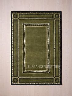 a green rug with an ornate border on the bottom and black border at the top