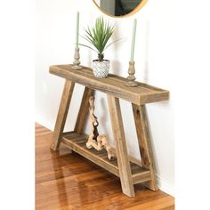 a wooden table with a mirror and plant on it