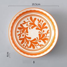 an orange and white bowl is shown with measurements