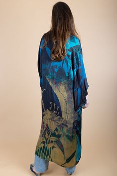 Our Vibrant Satin Kimono with abstract detailing features traditional kimono sleeves with modern floral motifs for a dash of electric flair. These polychromatic designs fill this flowy, relaxed kimono to give equal parts style and comfort. Style our kimono with a dress or casual outfit to indulge in a silky sensation all summer. Material: 100% Viscose Satin Length From HSP To Hem: 53.5" Sleeve Length: 13" Armhole Straight: 13.5" Shoulder Seam Length: 24.5" Bust 2.5 cm Below Underarm: 24" Made In Blue Printed Silk Kimono, Spring Kimono With Abstract Print, Spring Silk Kaftan With Abstract Print, Elegant Blue Floral Print Kimono, Blue Printed Kaftan With Kimono Sleeves, Spring Blue Silk Kaftan, Blue Silk Kaftan For Spring, Blue Floral Print Kaftan With Kimono Sleeves, Blue Kaftan With Kimono Sleeves