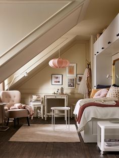 a bedroom with a bed, desk and chair under a slanted ceiling in an attic