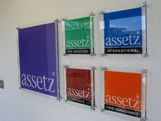 four glass signs mounted to the side of a wall