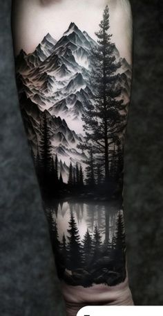 a man's arm with mountains and trees on it