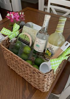 a wicker basket filled with liquor bottles on top of a wooden table