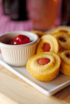 small pastries on a plate with ketchup in a bowl next to them