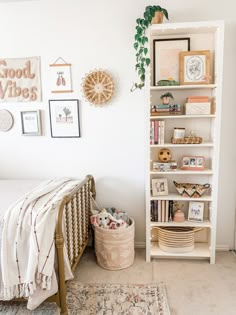 a bedroom with a bed, bookshelf and pictures on the wall