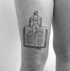 a woman with a book tattoo on her leg, reading the bible and drinking water