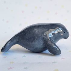 a small black seal sitting on top of a white table next to star patterned wallpaper