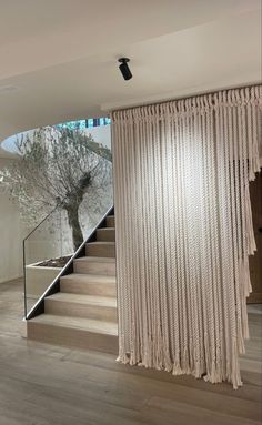 the stairs are made out of wood and have fringed curtains on them, as well as a tree in the background